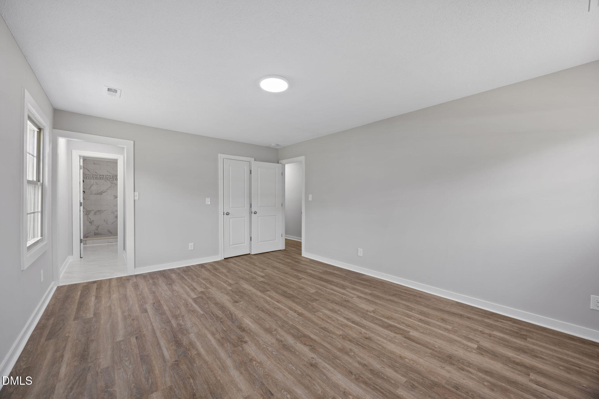 309 Rippling Stream Road Durham, NC 27704 - Photo 35 of 45 a view of an empty room with wooden floor and a window