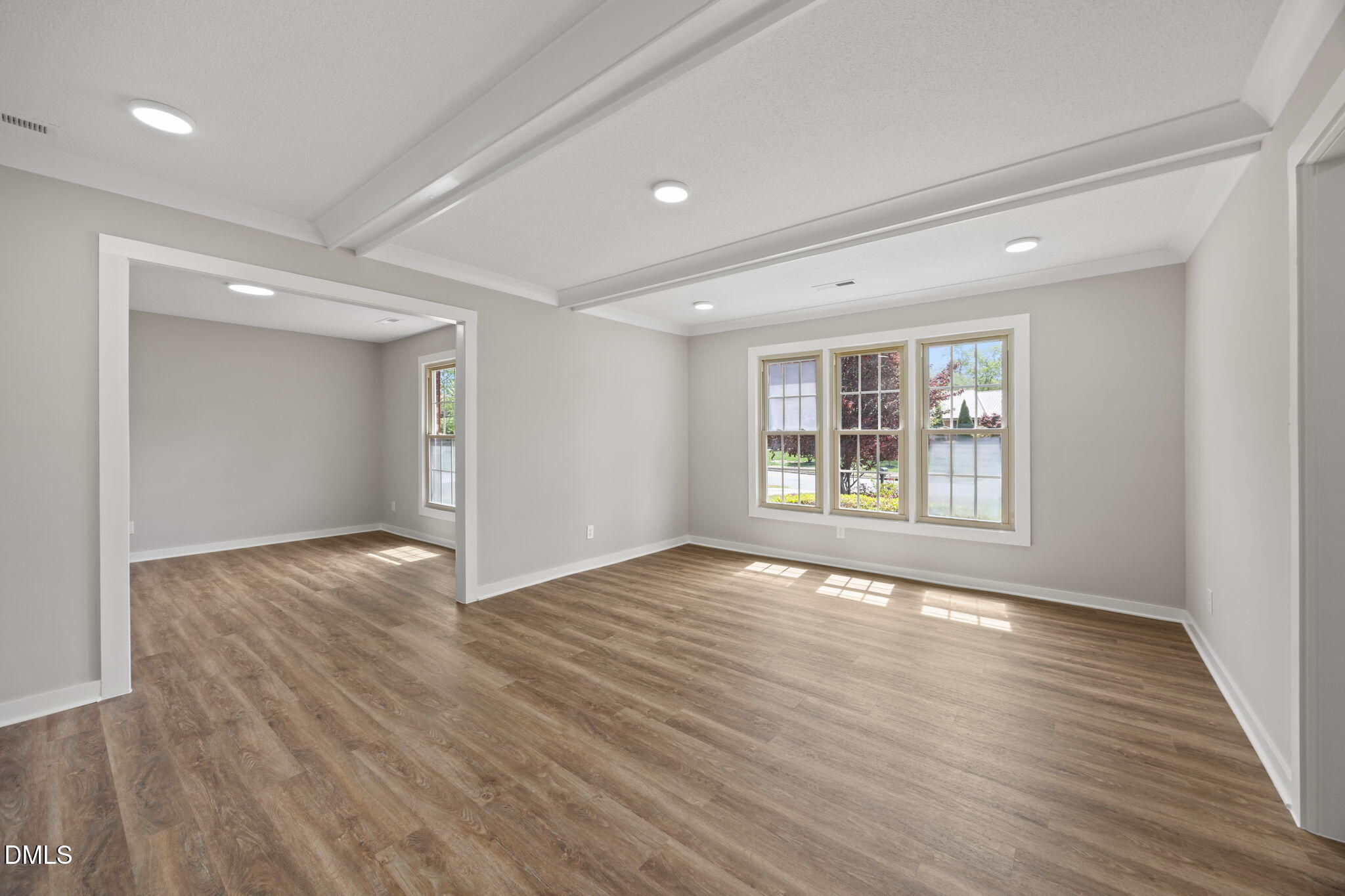 309 Rippling Stream Road Durham, NC 27704 - Photo 10 of 45 a view of an empty room with wooden floor and windows