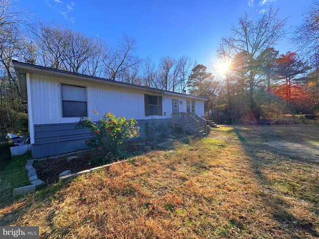 a view of a house with a yard and wooden fence