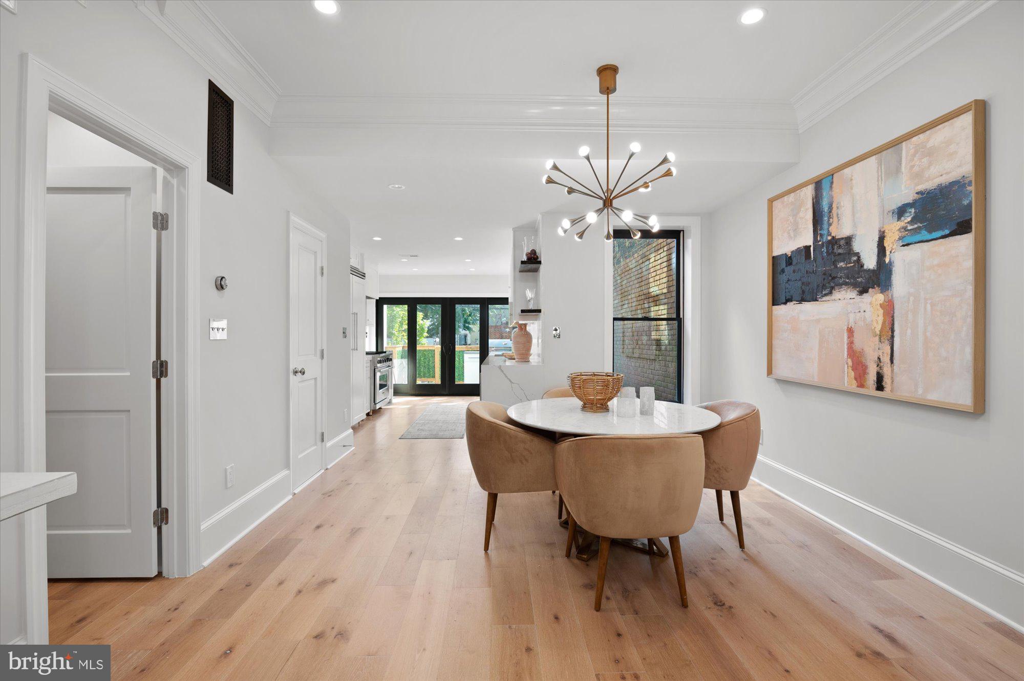 1831 12th Street Northwest Washington, DC 20009 - Photo 10 of 47 a dining room with wooden floor a chandelier a wooden table and chairs