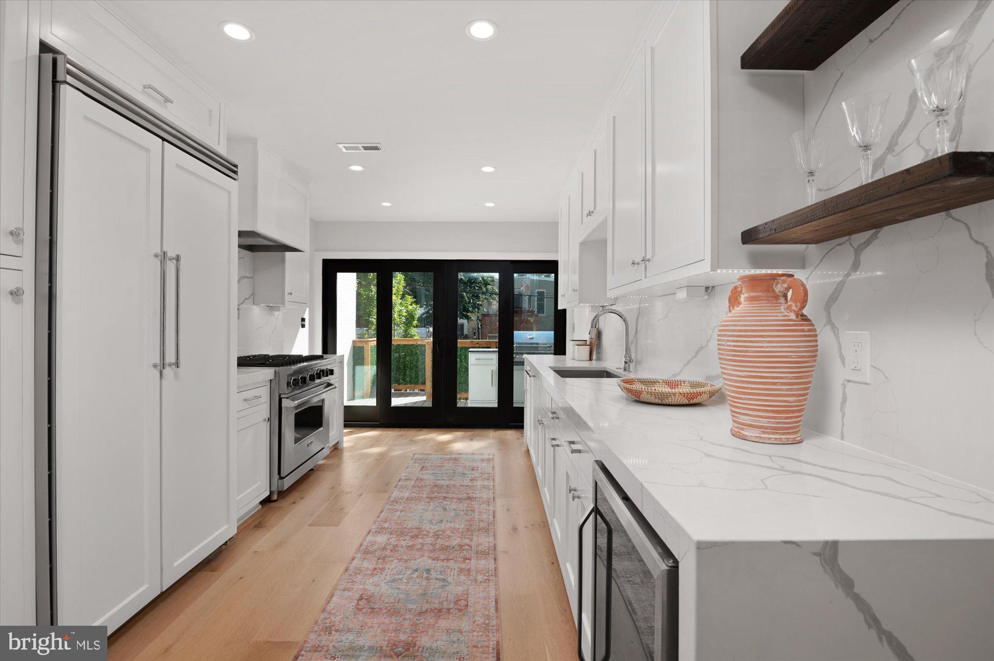 1831 12th Street Northwest Washington, DC 20009 - Photo 13 of 47 a kitchen with granite countertop a sink a counter top space stainless steel appliances and cabinets