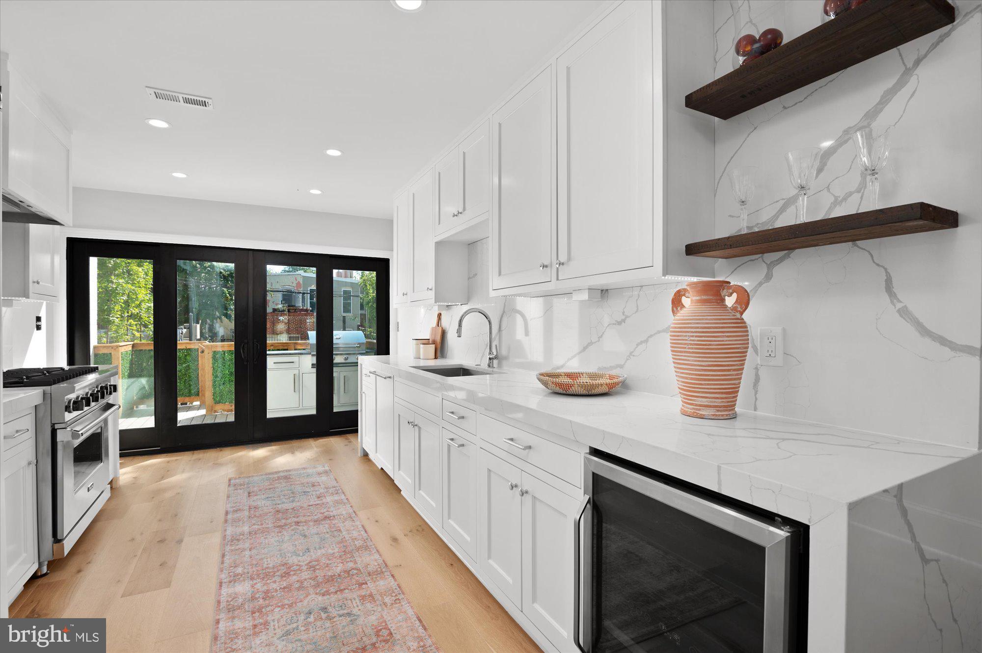 1831 12th Street Northwest Washington, DC 20009 - Photo 14 of 47 a large kitchen with stainless steel appliances granite countertop a sink and a white cabinets
