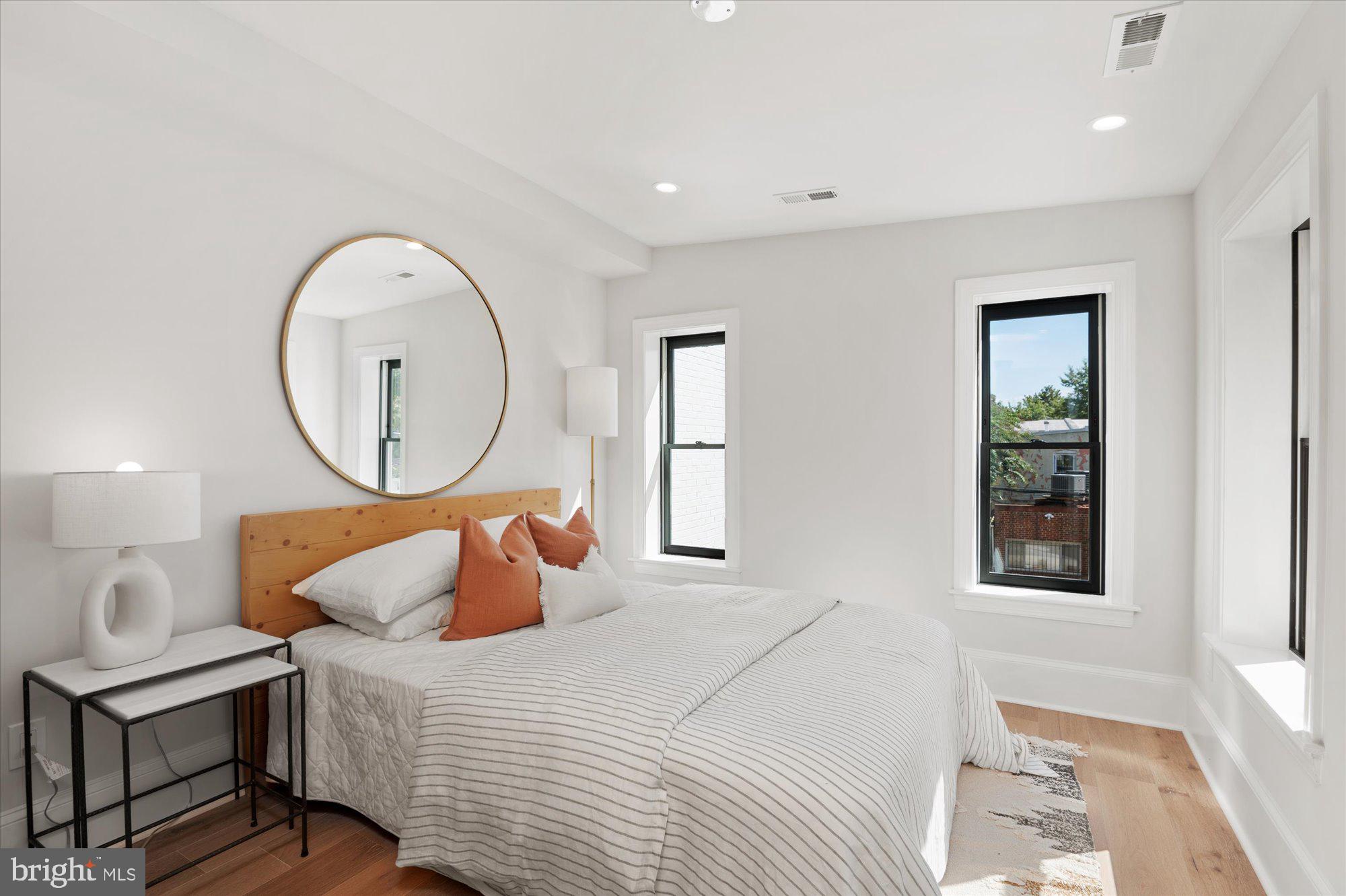 1831 12th Street Northwest Washington, DC 20009 - Photo 30 of 47 a bedroom with a bed a mirror and a window