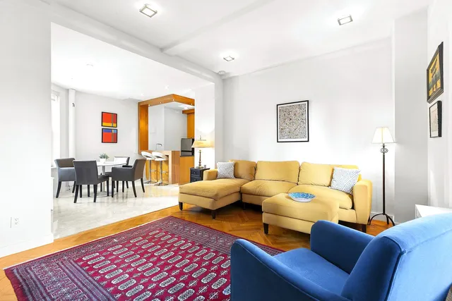 a living room with furniture and a dining table