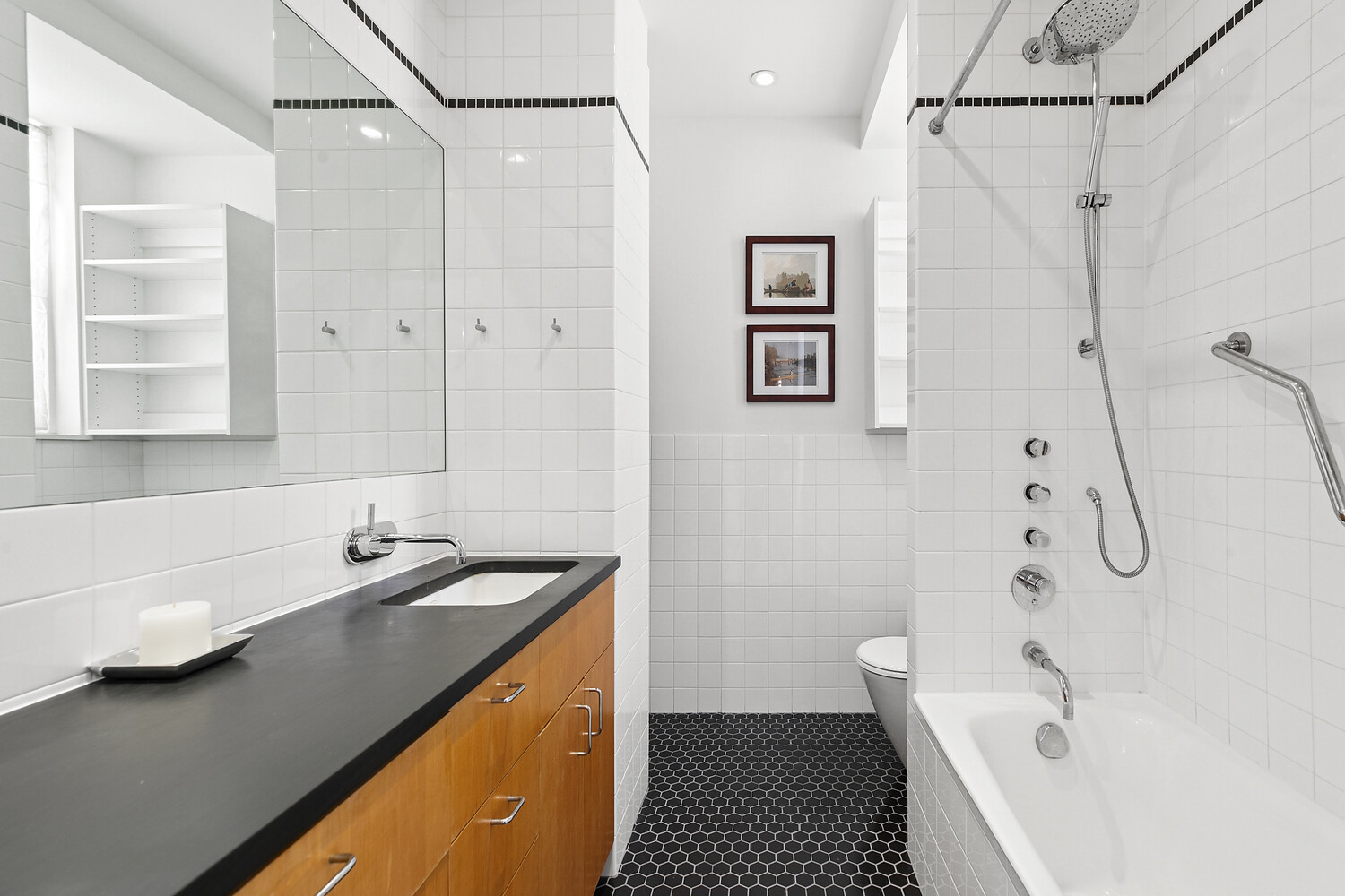 156 East 79th Street, Unit 9F Manhattan, NY 10075 - Photo 9 of 12 a bathroom with a tub sink and mirror