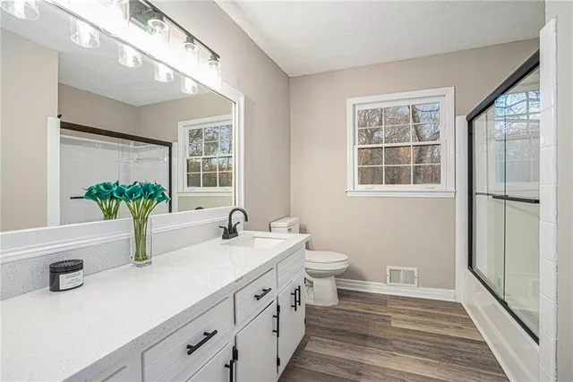 a bathroom with a double vanity sink a toilet and a window