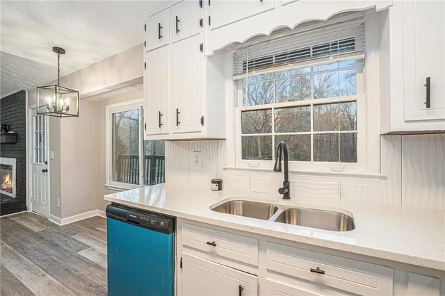 a kitchen with stainless steel appliances a sink a window and a wooden floor