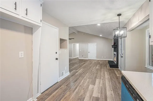 a view of a room with wooden floor staircase and a kitchen