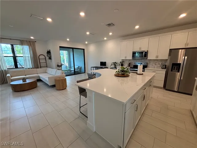 a kitchen with a sink a counter top space stainless steel appliances and cabinets
