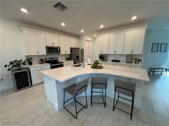a kitchen with a sink a counter top space appliances and cabinets