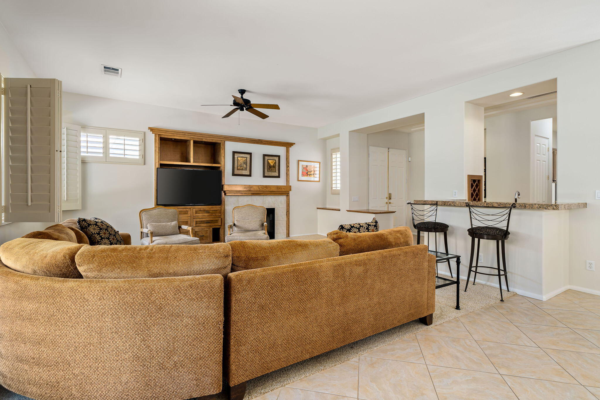 54275 Riviera La Quinta, CA 92253 - Photo 17 of 50 a living room with furniture a flat screen tv and a fireplace