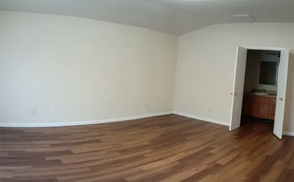a view of an empty room and wooden floor