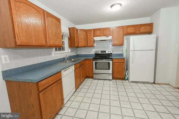 a view of a kitchen with wooden floor and a sink
