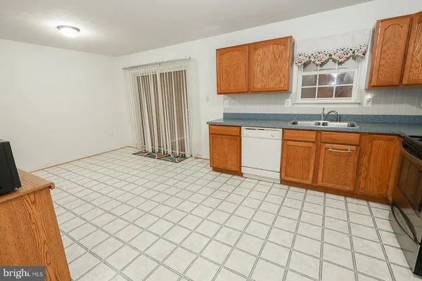 a kitchen with stainless steel appliances a sink a stove top oven a counter top space and cabinets