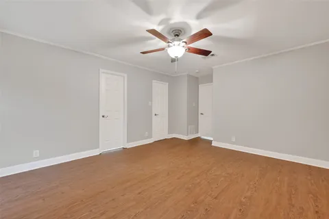 a view of an empty room with chandelier fan and a ceiling fan