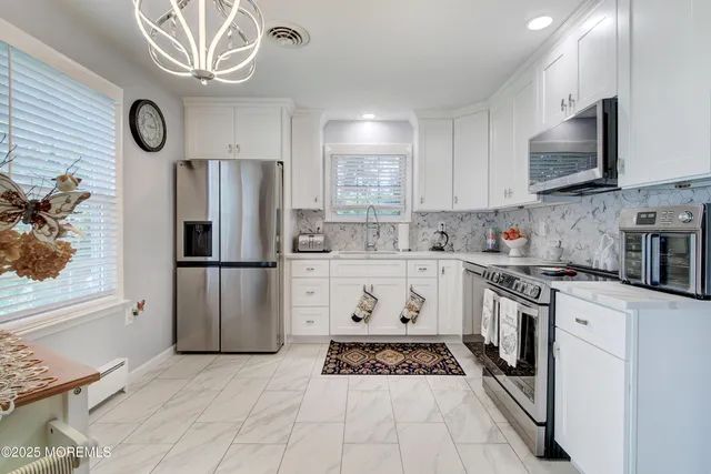 a kitchen with stainless steel appliances granite countertop a stove a refrigerator and a microwave