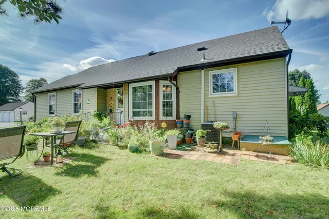 a backyard of a house with table and chairs