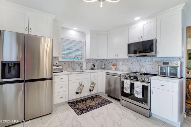 a kitchen with stainless steel appliances granite countertop a stove a sink and a refrigerator