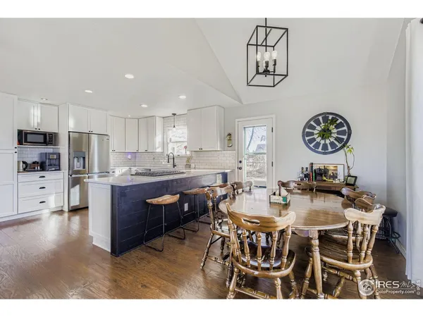 a view of a dining room with furniture a chandelier and wooden floor