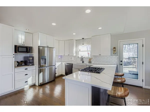 a kitchen with refrigerator cabinets and wooden floor