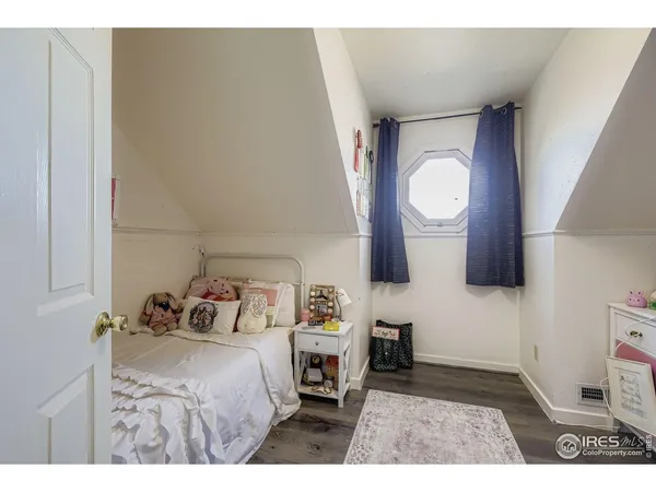 a bedroom with a bed and a lamp on dresser