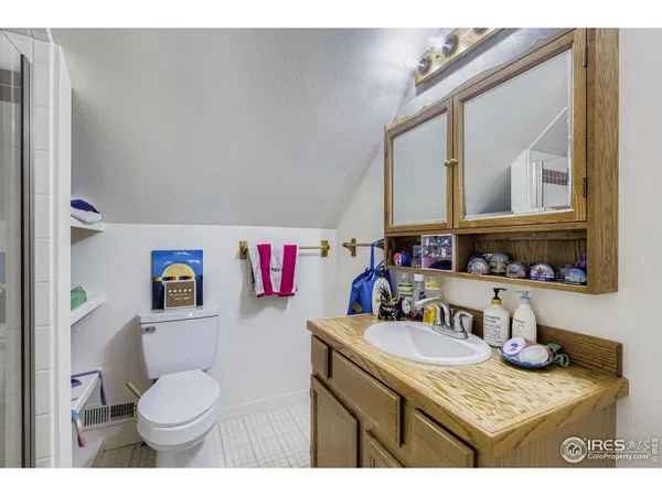 a bathroom with a granite countertop toilet sink and mirror