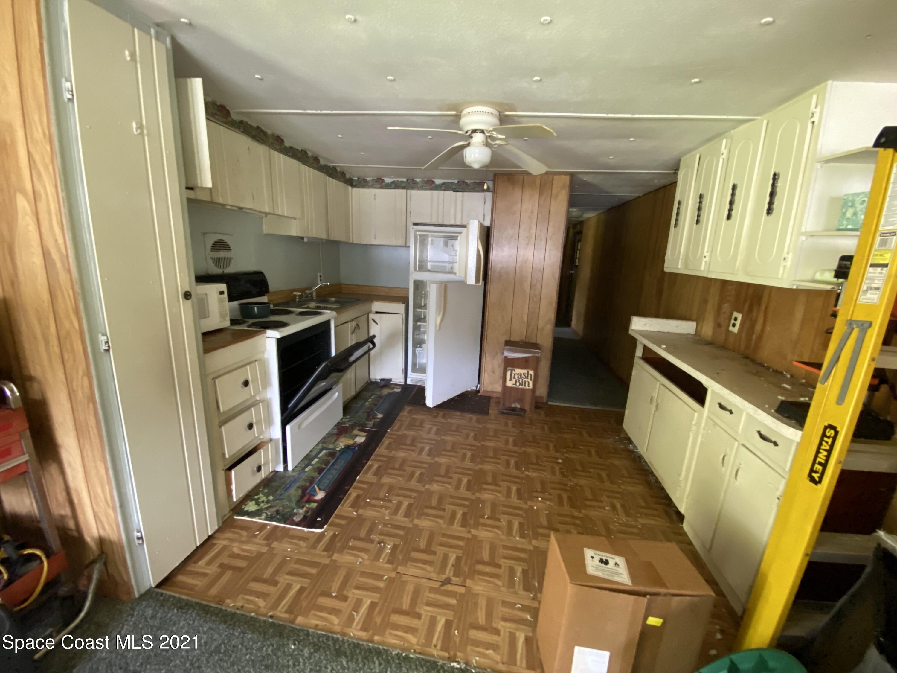 23903 Coon Road Astor, FL 32102 - Photo 14 of 19 a kitchen with stainless steel appliances granite countertop a refrigerator and a stove
