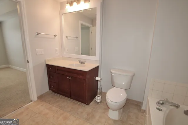 a bathroom with a toilet a sink and mirror