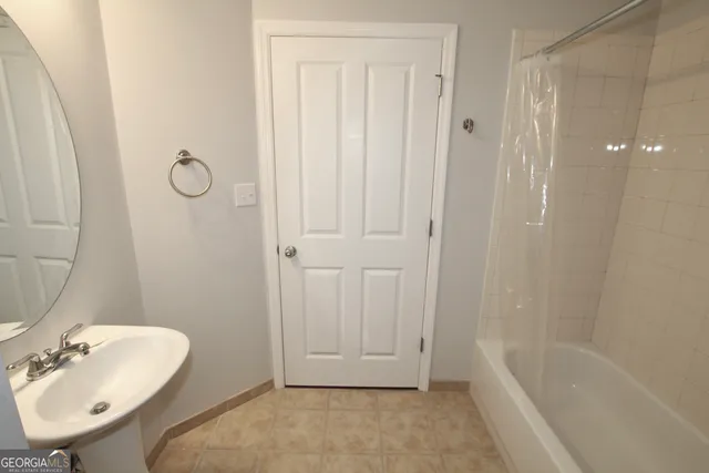 a bathroom with a tub a sink and mirror