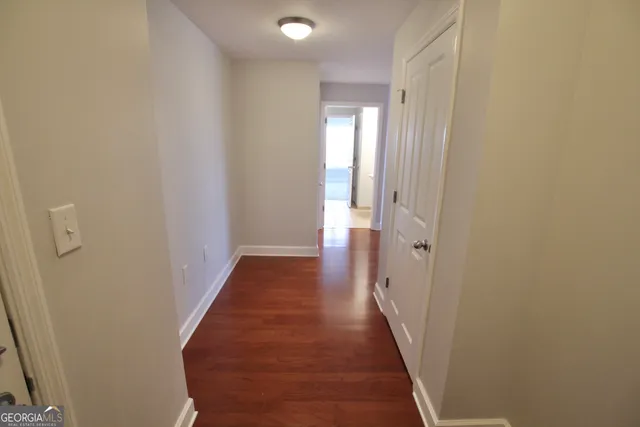 a view of a hallway with wooden floor