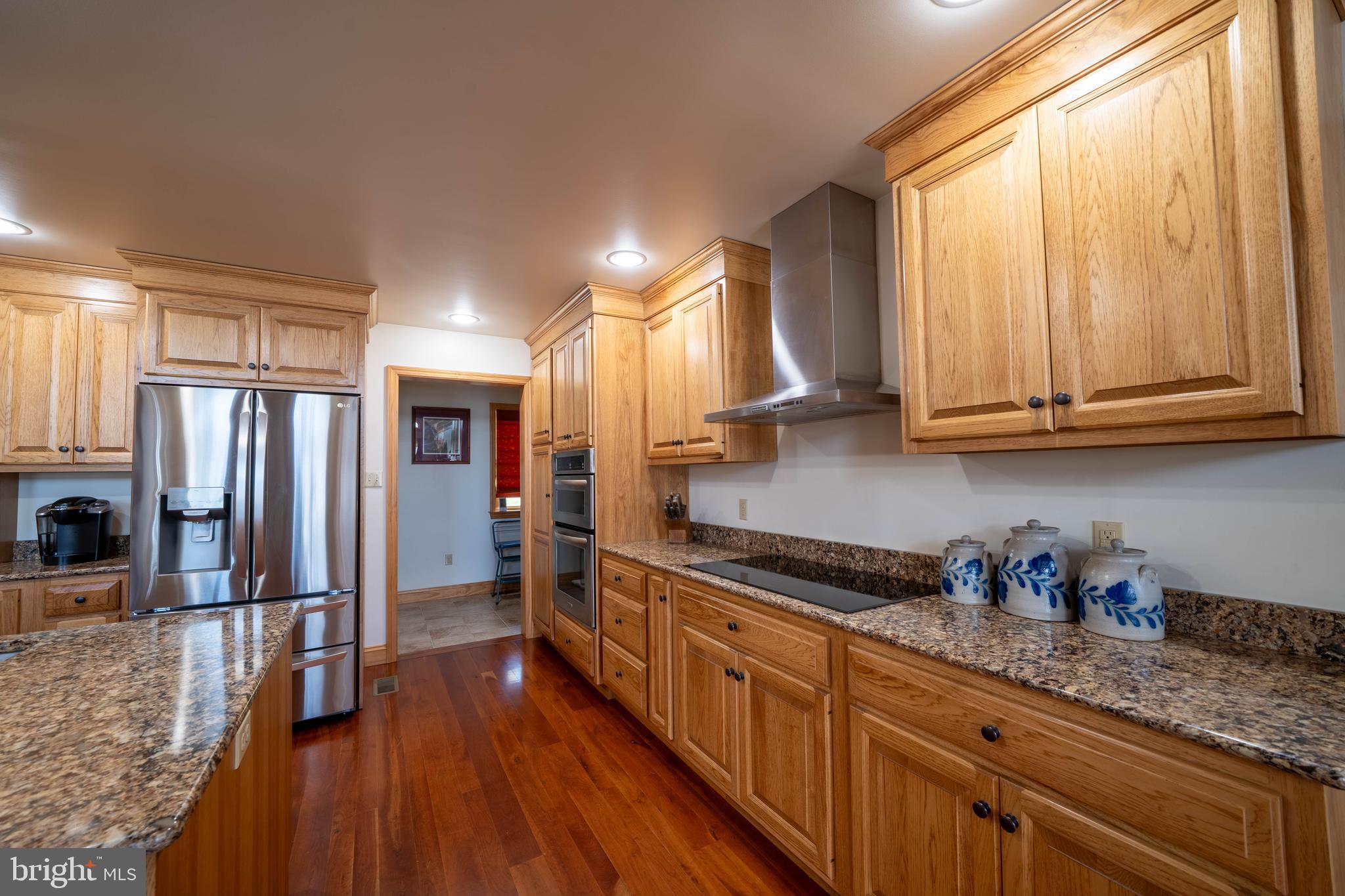 1020 Clark Hill Road Mount Pleasant Mills, PA 17853 - Photo 51 of 76 a kitchen with stainless steel appliances granite countertop a refrigerator a sink dishwasher a stove and white countertops with wooden floor