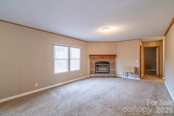 an empty room with fireplace and windows