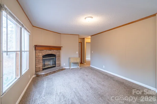 a view of empty room with a fireplace and window