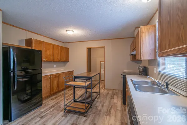 a kitchen with stainless steel appliances granite countertop a refrigerator sink and stove