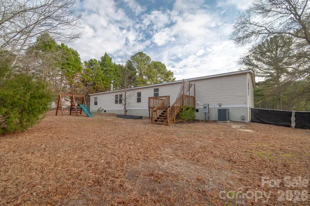 a view of a house with backyard and trees