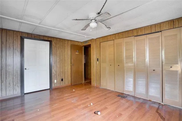 a view of a big room with wooden floor and a ceiling fan