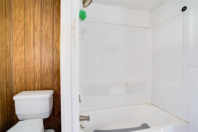 a bathroom with a toilet and a shower curtain