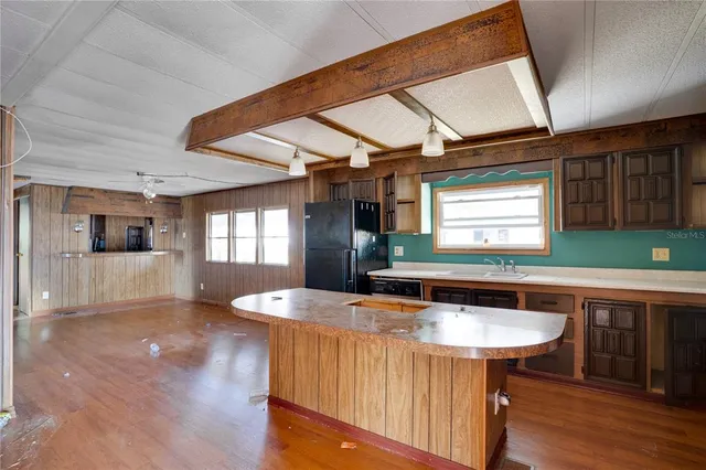 a kitchen that has a sink a window and chairs