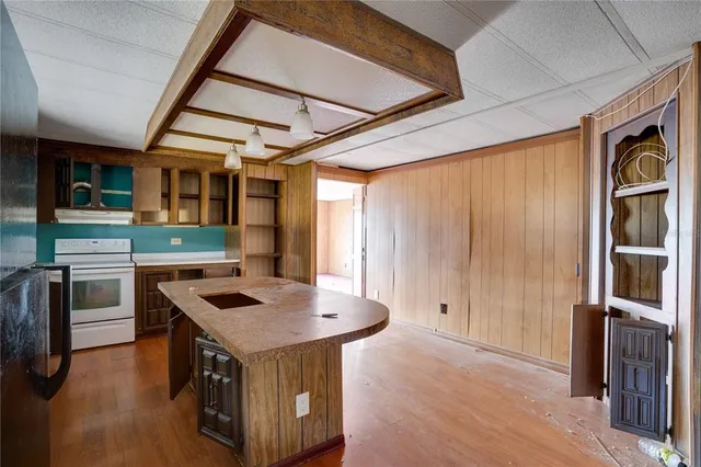 a kitchen that has a sink a stove and a wooden floor