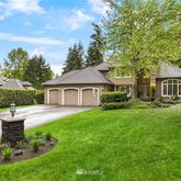 a front view of a house with a yard and trees