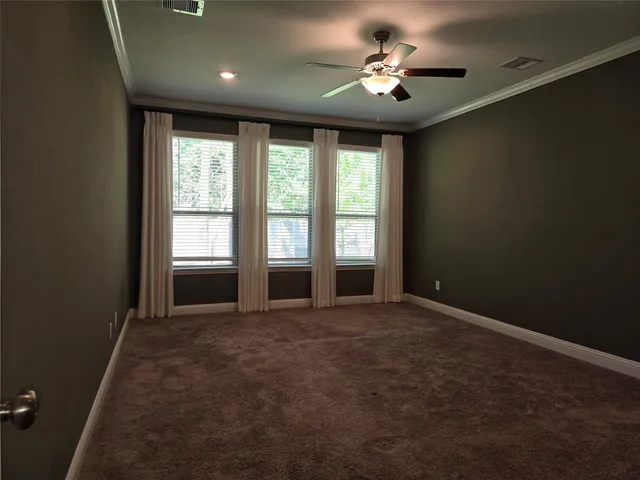 an empty room with windows and ceiling fan