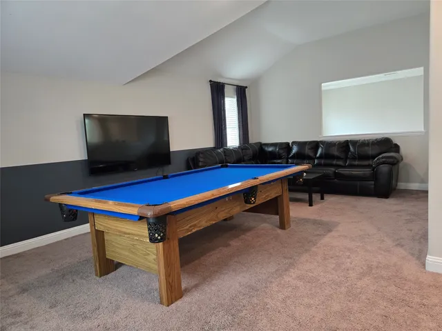 a room with furniture pool table and flat screen tv