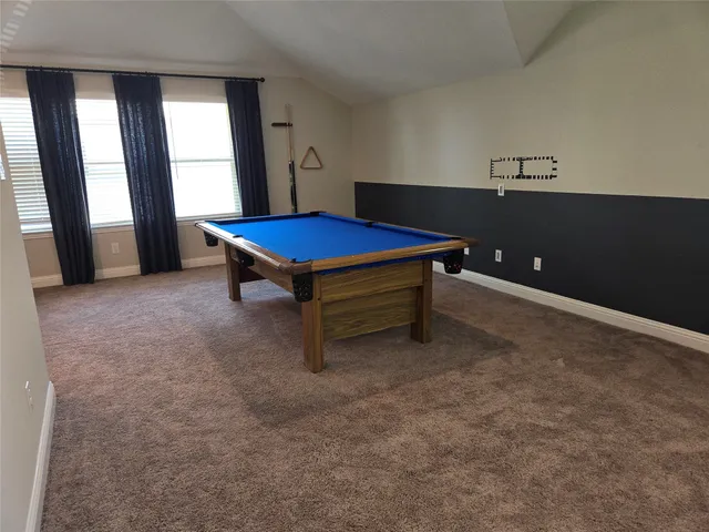 a living room with furniture pool table and a window