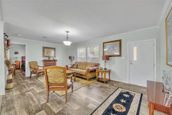 a living room with furniture a flat screen tv and a chandelier