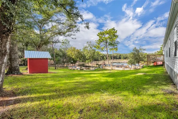 an aerial view of a house with a yard and lake view