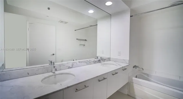 a bathroom with a granite countertop sink mirror and double