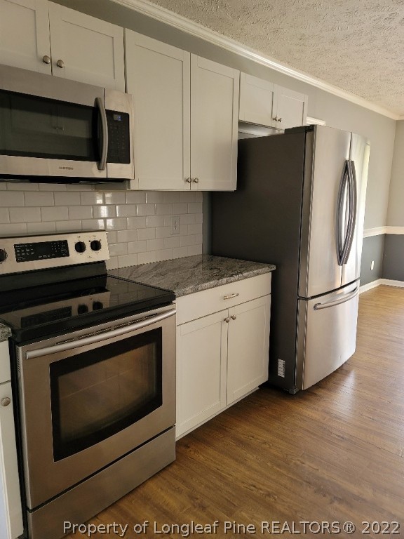 5042 Summer Ridge Road Fayetteville, NC 28303 - Photo 3 of 17 a kitchen with stainless steel appliances white cabinets white stove a microwave and a refrigerator