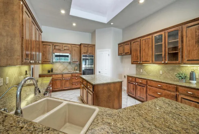 a kitchen with stainless steel appliances granite countertop a sink and a stove