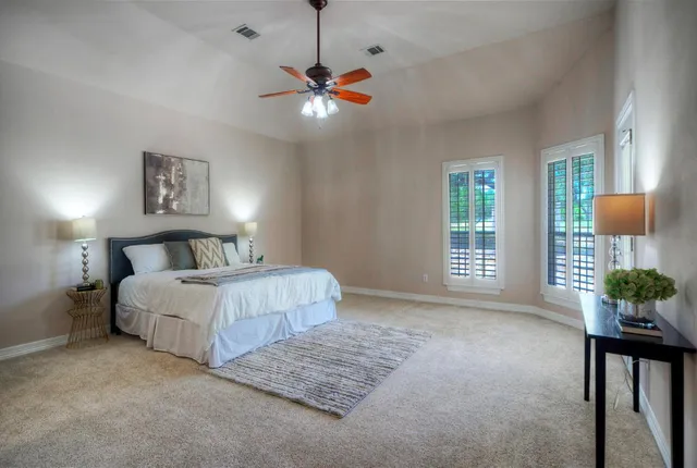 a bedroom with a large bed chandelier and a window