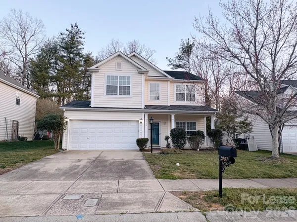 a front view of a house with a yard and trees